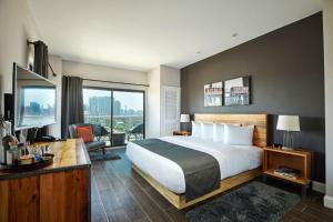 a hotel room with a large bed and a television at Ravel Hotel Trademark Collection by Wyndham in Queens