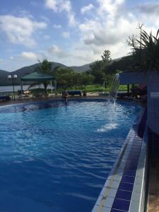 a person in a swimming pool with a fountain at AP Beira da Lagoa da Conceição in Florianópolis