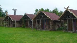 una casa con una valla en el césped en TammeKännu Kämpingud, en Mammaste