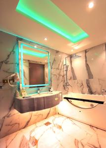 W łazience znajduje się umywalka, lustro i wanna. w obiekcie Nusk Al Madinah w Medynie