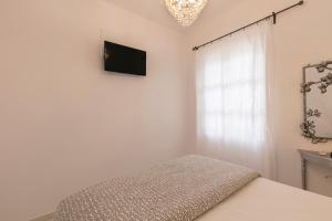 a bedroom with a bed and a television on the wall at Apartment Sunrise in Hydra