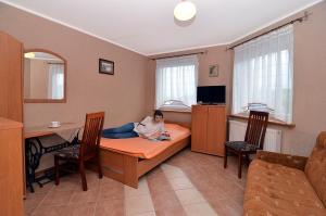 Eine Frau auf einem Bett in einem Zimmer in der Unterkunft Willalux in Mielno
