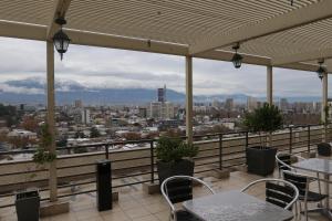a balcony with tables and chairs and a view of the city at Departamento Santiago Centro in Santiago