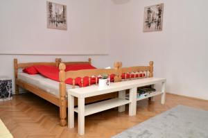 um quarto com uma cama com almofadas vermelhas e uma mesa em Apartments Villa Saray em Ohrid