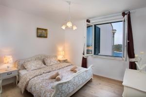 una camera con un letto e una grande finestra di Apartment Zlatni Potok - View of the Old Town & 15 Minute Walk to the Center a Dubrovnik