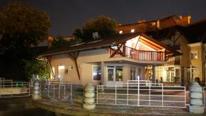 a house with a balcony on top of it at night at Centrum Lux Apartman in Kaposvár