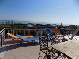 a group of chairs and tables on a balcony with the ocean at B&B Falcone in Ortona
