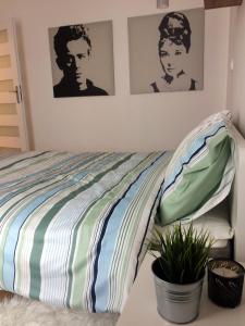 sypialnia z łóżkiem z dwoma obrazami na ścianie w obiekcie Apartament Zwycięstwa 98 w Koszalinie