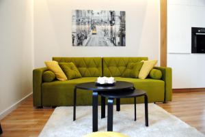 a living room with a green couch and a table at Apartament Zwycięstwa 98 in Koszalin