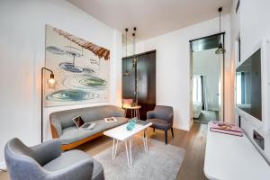 ein Wohnzimmer mit einem Sofa, Stühlen und einem Tisch in der Unterkunft Le A in Paris