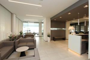 a lobby with a couch and a table and a counter at Hotel Derby S in Lido di Jesolo