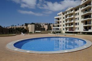 uma grande piscina em frente a um edifício em FLH Garajau Balcony with Pool no Caniço