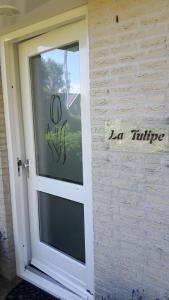 a door to a house with a sign on it at La Tulipe in Egmond aan den Hoef
