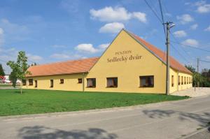 塞德萊茨的住宿－Sedlecký Dvůr，黄色的建筑,旁边标有标志