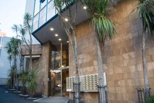 a building with palm trees in front of it at Snug Studio in the heart of the city in Auckland