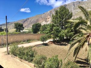 un giardino alberato e una montagna sullo sfondo di Trapani Emotions apartment a Valderice