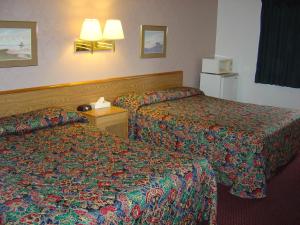 um quarto de hotel com duas camas e um frigorífico em Wakota Inn and Suites em Cottage Grove