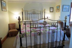 Un dormitorio con una cama de metal con flores. en McCloud House, en Port Noarlunga