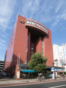 um grande edifício vermelho com um relógio em Yamagata Nanokamachi Washington Hotel em Yamagata