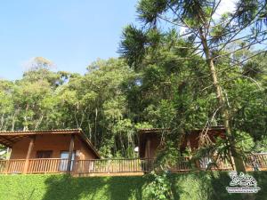 a house with a balcony and trees in the background at Espaço Recanto do Pico in Santo Antônio do Pinhal