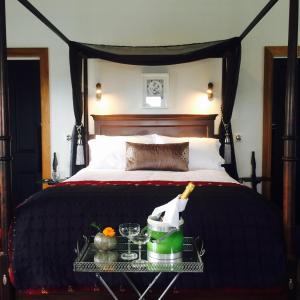 ein Schlafzimmer mit einem Bett und ein Tablett mit einer Flasche Champagner in der Unterkunft Marriner's Boutique Guesthouses in Rawene