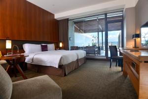 una camera d'albergo con un letto grande e una scrivania di Silks Place Yilan a Città di Yilan