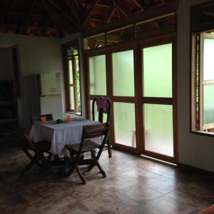 a table and chairs in a room with windows at La Toscana Campestre in Viotá