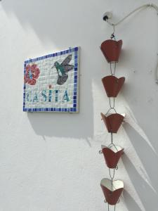 a picture of a mosaic on a wall with three bird sculptures at Les Gîtes de CASITA By kreyol animal in Grand-Bourg