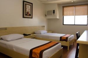 Postel nebo postele na pokoji v ubytování M Suites Hotel