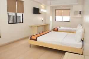 Postel nebo postele na pokoji v ubytování M Suites Hotel