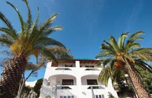 a white building with palm trees in front of it at Hotel Al Bosco in Ischia