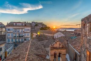 vista sui tetti di una città al tramonto di Papalina Suite a Città di Corfù