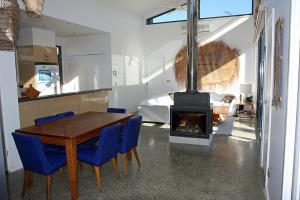 a dining room with a wood table and a fireplace at Seaside Idaho in Point Lonsdale