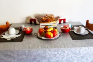 una mesa con un plato de fruta. en Caricia, en Alghero