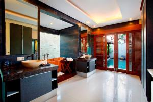 a bathroom with a tub and a sink in it at Lalasa Villas Canggu in Canggu