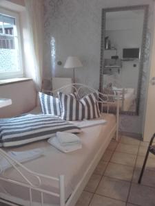 a living room with a bed and a mirror at Gästehaus Strandkonsulat in Scharbeutz
