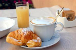 a plate with a cup of coffee and a pastry at La rosa di Rebecca in Monopoli
