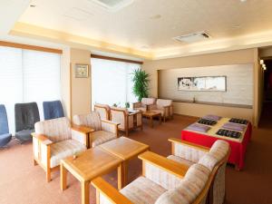 a waiting room with chairs and a bed and a table at Kotohira Riverside Hotel in Kotohira