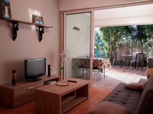 ein Wohnzimmer mit einem Sofa und einem TV in der Unterkunft Stella Foresta in Saint-Leu