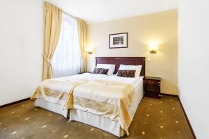 Postel nebo postele na pokoji v ubytování Hotel & Apartments U Černého orla