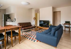 un salon avec un canapé bleu et une table dans l'établissement Koko, à Fujikawaguchiko