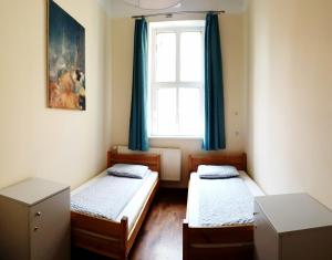 two beds in a room with a window at Hostel Orange Plus in Toruń