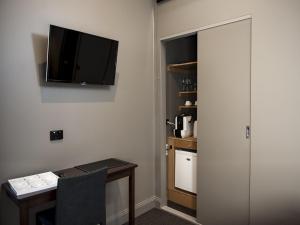 a small room with a television and a refrigerator at Criterion Hotel Sale in Sale