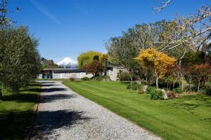 a gravel path in a yard with a mountain in the background at Ratanui Villas in New Plymouth