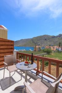 a table and chairs on a balcony with a view of the ocean at Asymi Residences in Symi