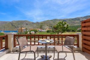 a patio with a table and chairs on a balcony at Asymi Residences in Symi