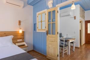 a bedroom with a bed and a desk and a table at Asymi Residences in Symi