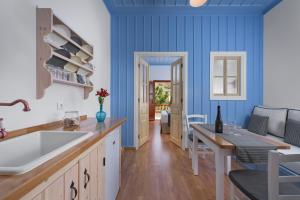 a kitchen with blue walls and a white sink at Asymi Residences in Symi