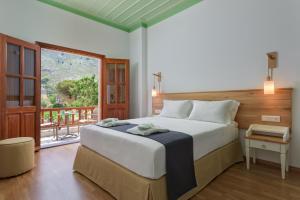 een slaapkamer met een groot bed en een groot raam bij Asymi Residences in Symi