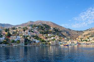 a view of a town on a hill next to the water at Asymi Residences in Symi